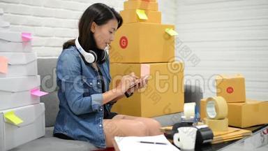 创办小企业企业家中小企业或自由职业者亚洲妇女在网上市场包装与盒在家概念